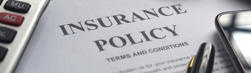 Homeowners Insurance policy with calculator and pen.